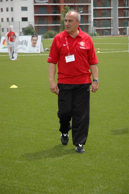José Costa walking on an artificial pitch in a red polo shirt