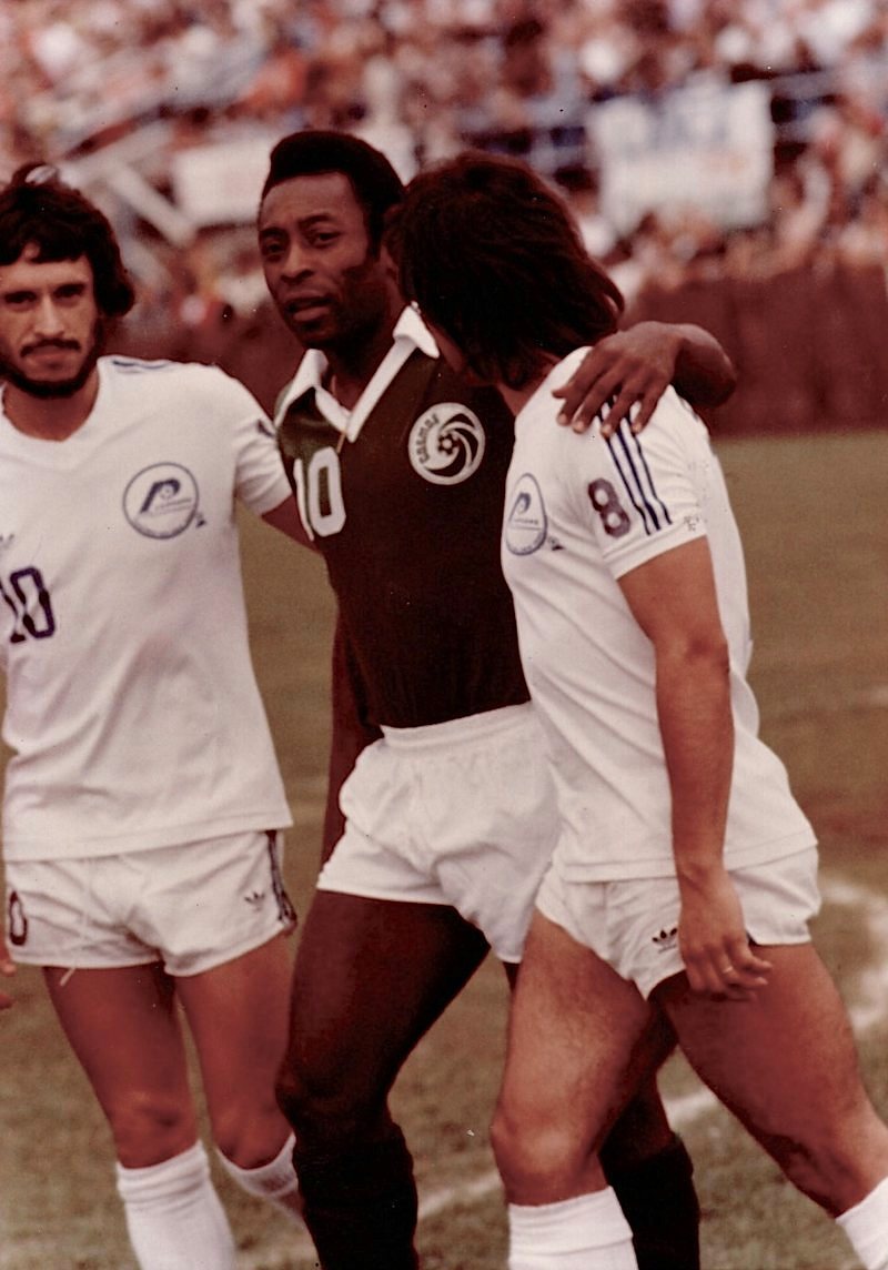 Pelé in the green New York Cosmos No. 10 shirt with his arm around José Costa, who wears the white Rochester Lancers No. 8 shirt