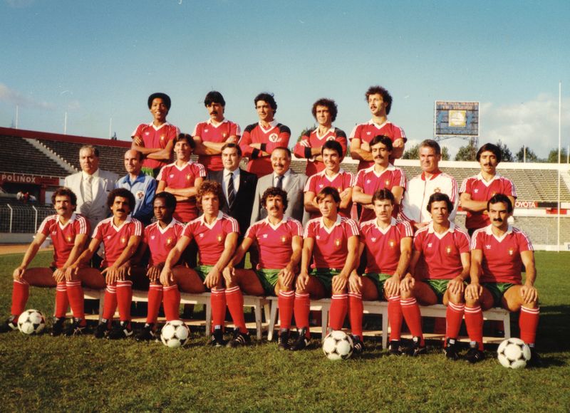 Portugal squad photo in red shirts and green shorts, with officials in suits in the middle
