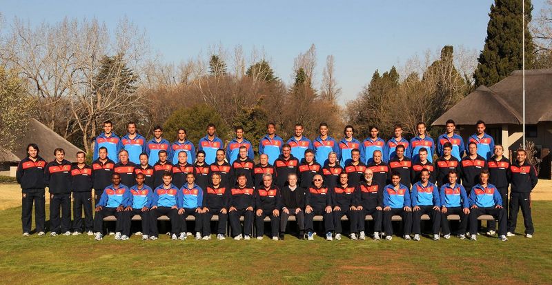 Group photo of the Portugal players and staff on a lawn, in tracksuits, in three rows