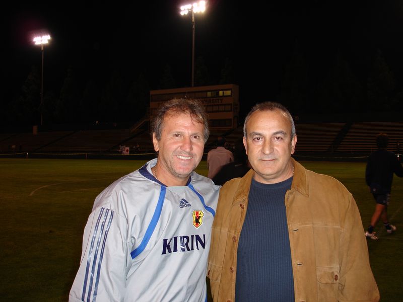 José Costa standing next to Zico on a pitch at night